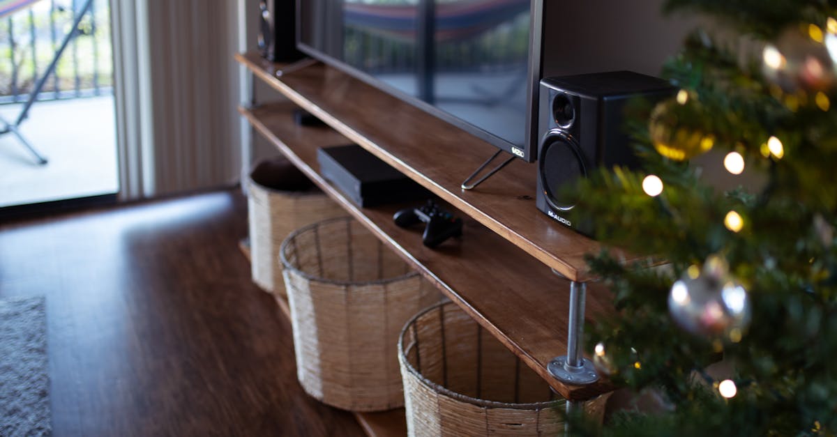 Cozy living room featuring a TV stand, baskets, speaker setup, and Christmas tree decor.