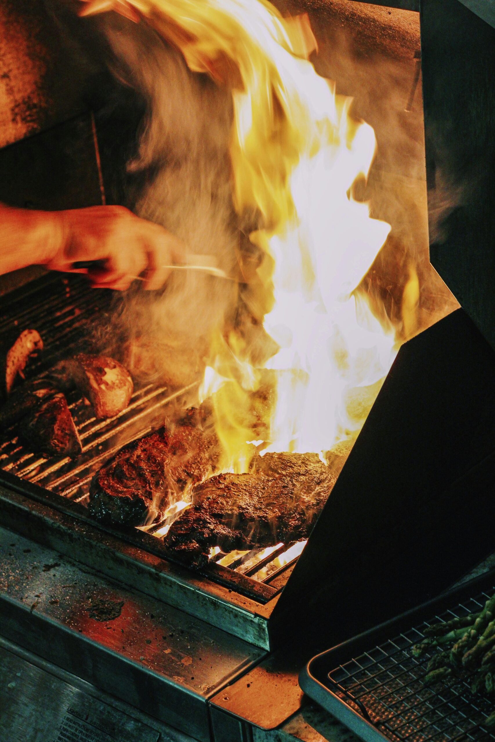 Close-up of steak grilling over high flames, a classic Atlanta barbecue scene.