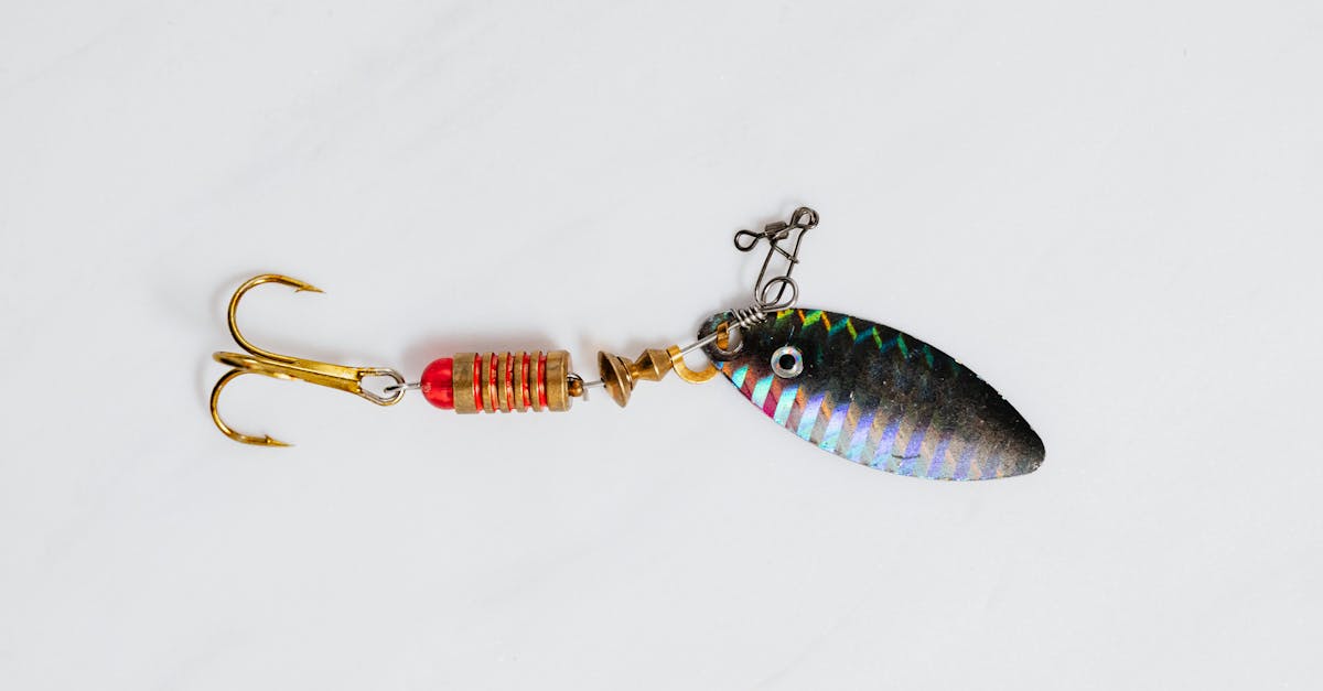 A close-up shot of a colorful metallic fishing lure with hook on a white surface.