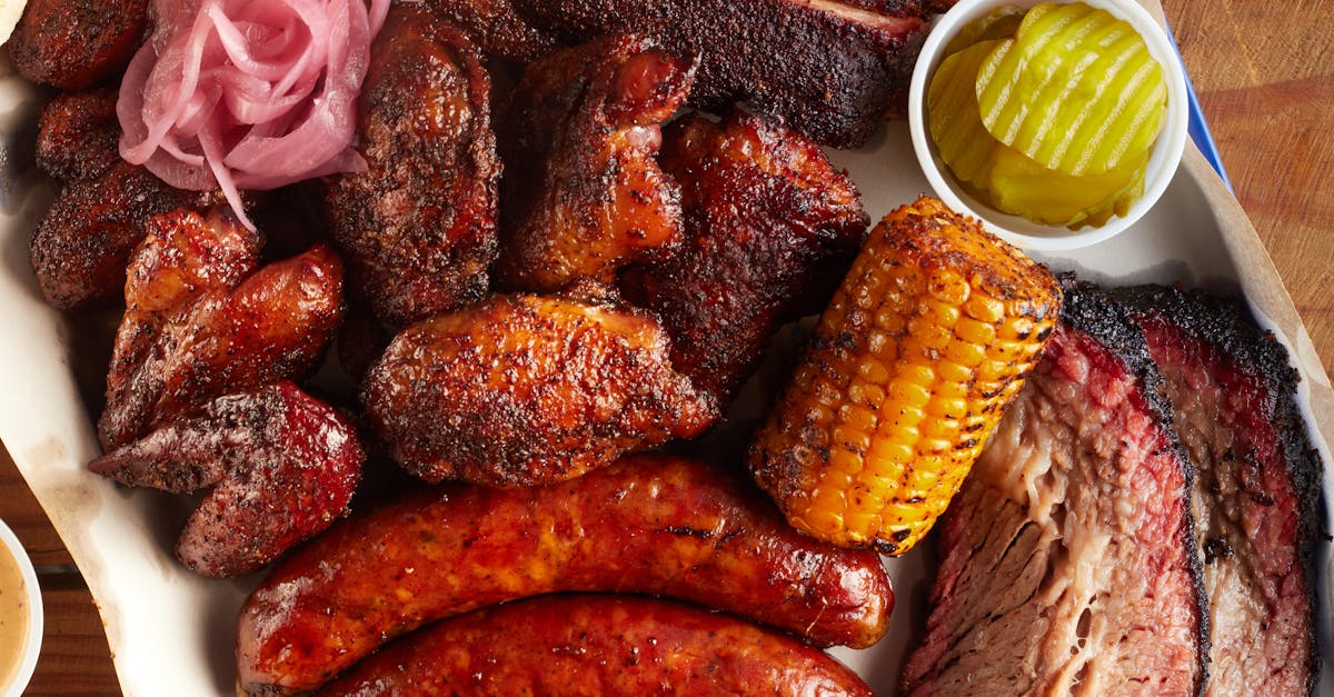 Top view of a succulent barbecue meat platter featuring sausages, brisket, and corn, perfect for foodies.