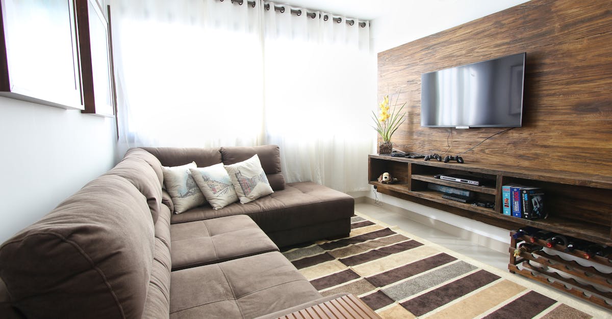 Stylish modern living room featuring a brown sofa, wall-mounted TV, and interior decor.